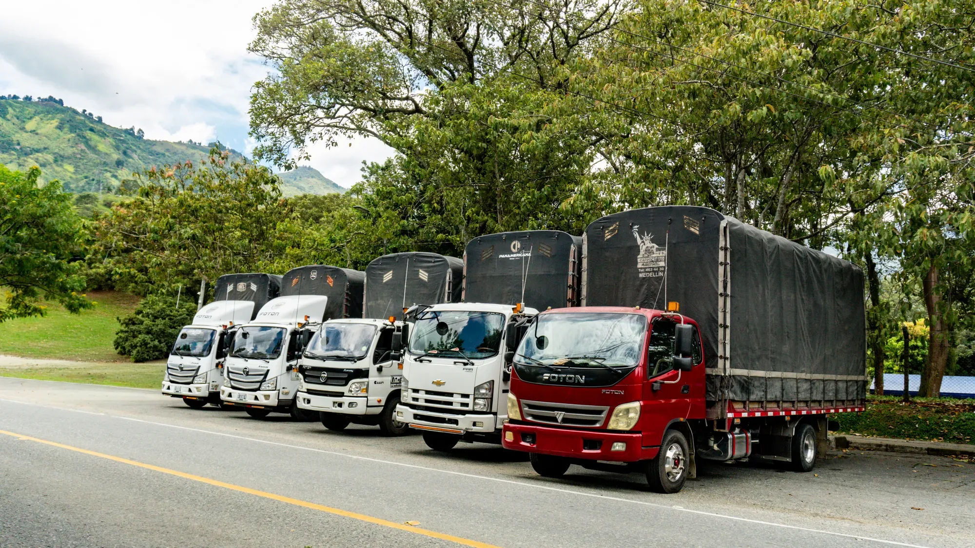 Flota de camiones de G&S Conexiones Estratégicas alineada sobre una carretera de Antioquia